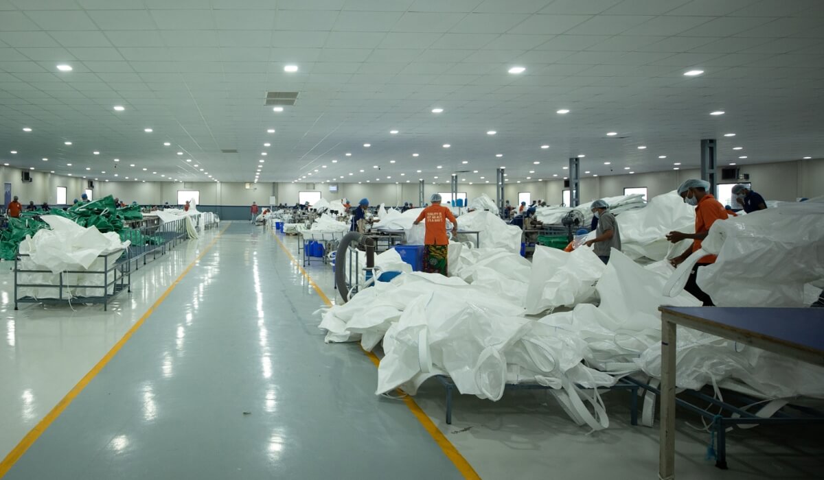 Industrial workforce inspecting and assembling woven polypropylene bulk bags inside a manufacturer in India